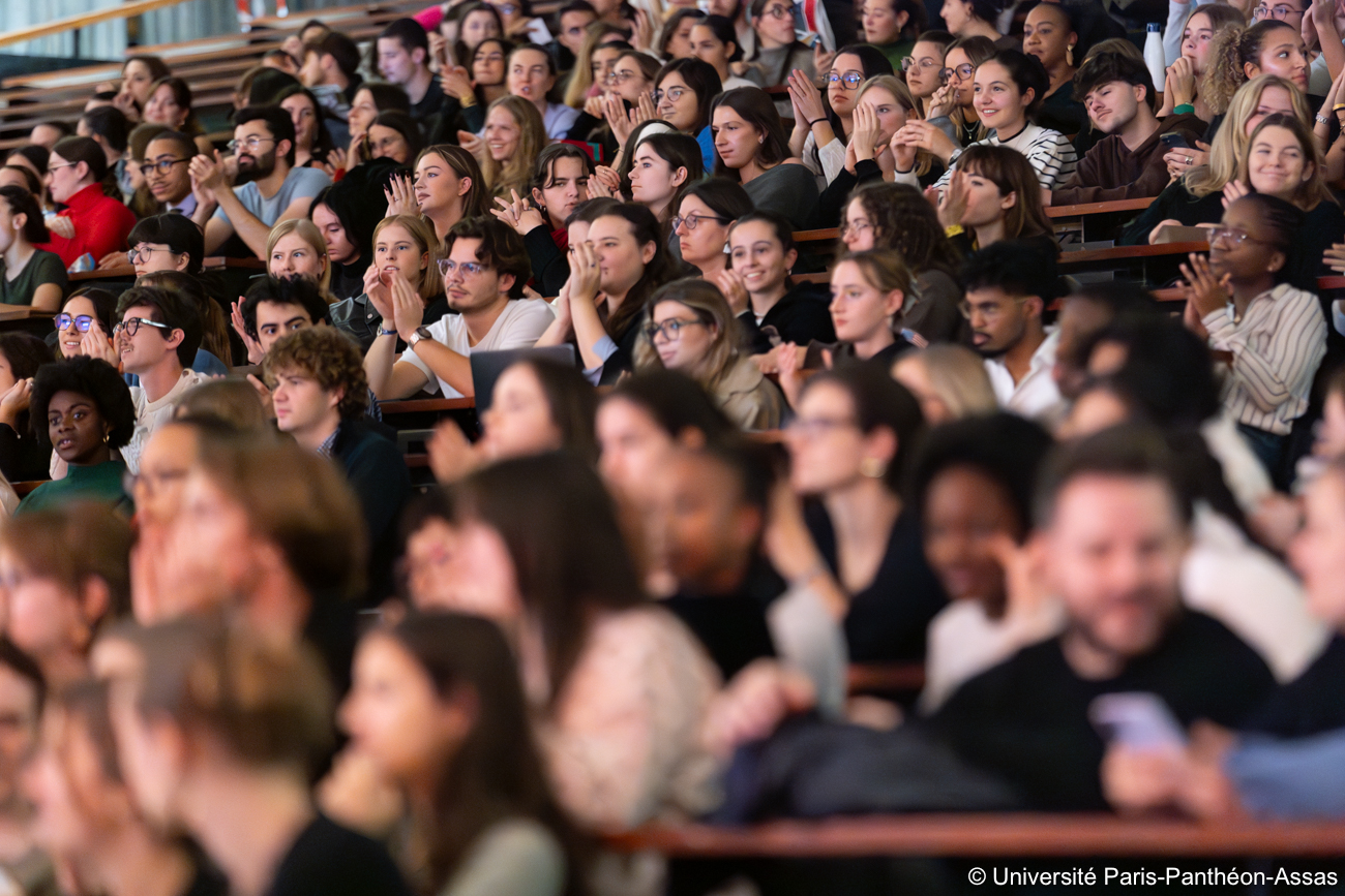 Les étudiants sont assis dans l'amphithéâtre et et applaudissent en attendant le début de la projection
